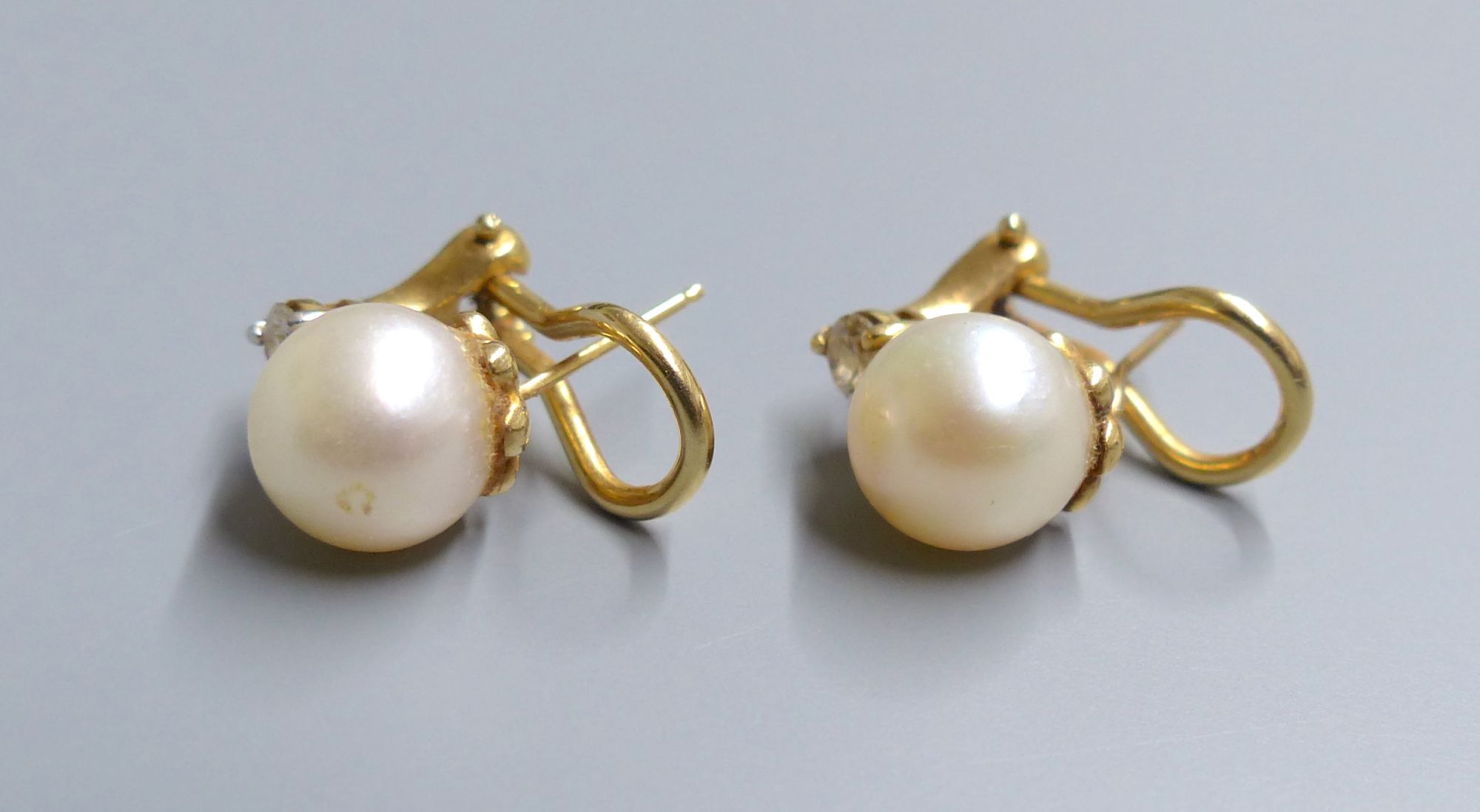 A modern pair of 14k, cultured pearl and diamond set earclips, gross 5.1 grams,